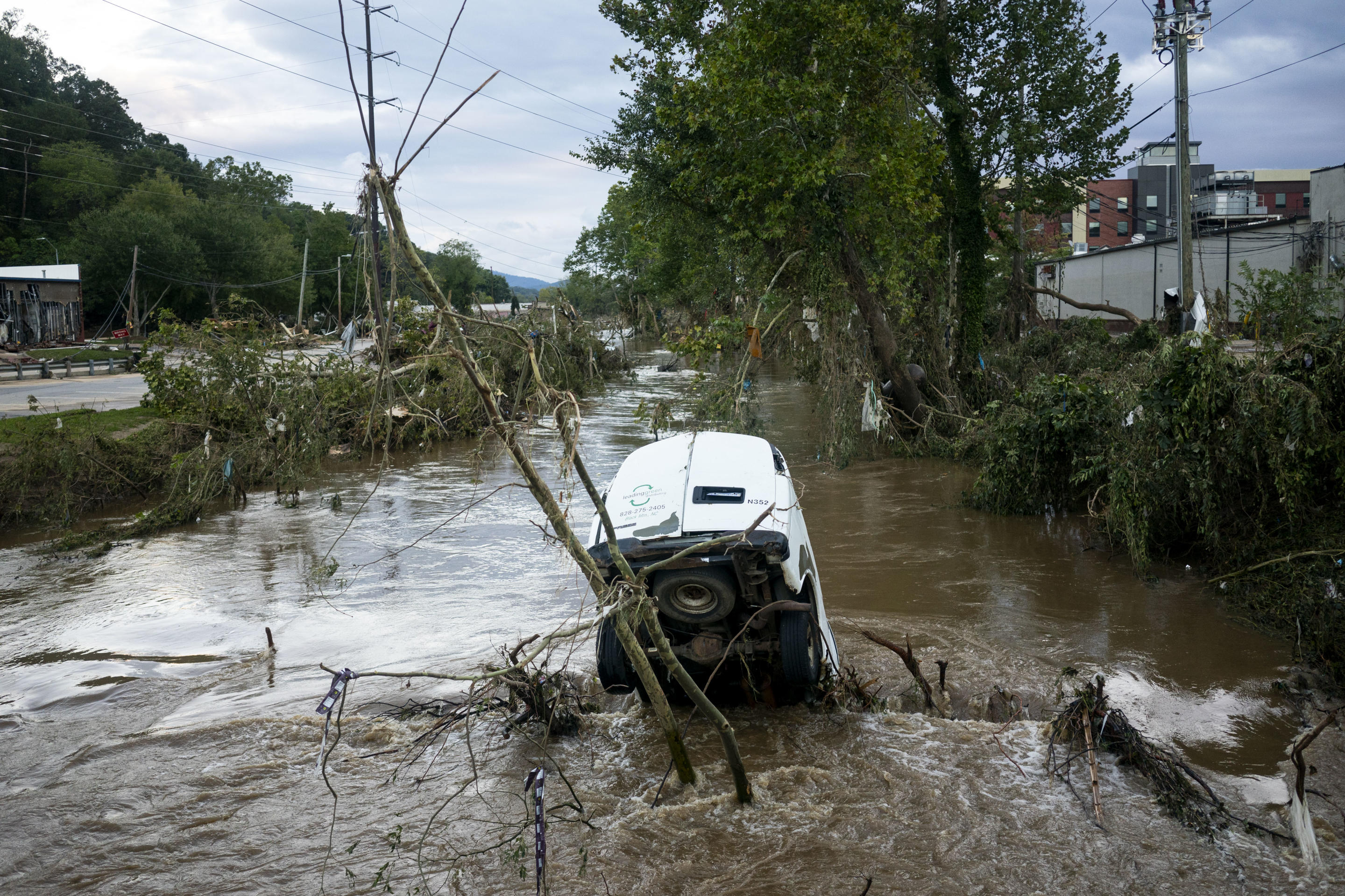 A van is partially submerged in the Swannanoa River.