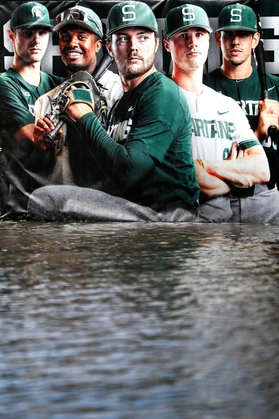 An advertisement for Michigan State baseball is displayed outside the flooded entrance to the McLane Baseball Stadium on Thursday, April 6, 2023, in East Lansing.