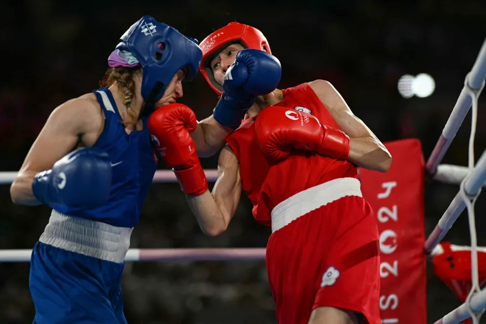 TOPSHOT - Taiwan's Lin Yu-ting and Turkey's Esra Yildiz Kahraman (Blue) compete in the women's 57kg semi-final boxing match during the Paris 2024 Olympic Games at the Roland-Garros Stadium, in Paris on August 7, 2024. (Photo by Mauro PIMENTEL / AFP) (Photo by MAURO PIMENTEL/AFP via Getty Images)