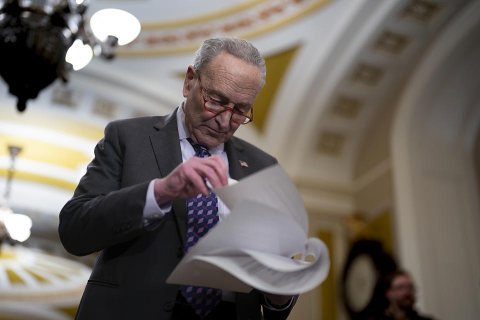 Senate Majority Leader Chuck Schumer, D-N.Y., looks over papers before he takes questions from reporters outside the Senate chamber, at the Capitol in Washington, Tuesday, Nov. 28, 2023. President Joe Biden's nearly $106 billion aid package for Ukraine, Israel and other needs is sitting idle in Congress as Republicans are insisting on U.S.-Mexico border policy provisions in exchange for any new U.S. dollars for Ukraine in its fight against Russia. (AP Photo/J. Scott Applewhite)