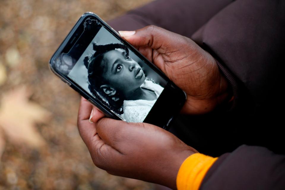 Rosamund Adoo-Kissi-Debrah holds her mobile phone displaying a photograph of her daughter EllaAFP/Getty