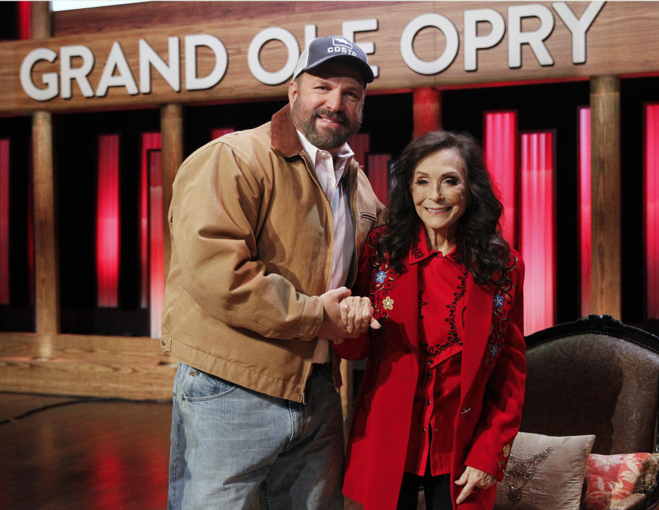 Country music legend Loretta Lynn and country star Garth Brooks leave the stage of the Grand Ole Opry House, Monday, Jan. 14, 2019, in Nashville, Tenn., after Lynn announced she will celebrate her 87th birthday with an all-star tribute concert featuring Brooks, Jack White, George Strait and others on April 1. (AP Photo/Mark Humphrey)