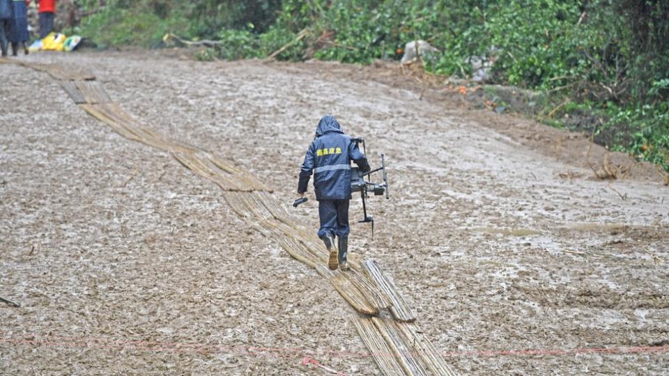 廣西梧州藤縣中國東航MU5735航班墜落事故墜落現場無人機操作人員在鋪上竹子的泥濘路面上行進（新華社圖片23/3/2022）