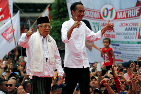 Indonesia's incumbent presidential candidate Joko Widodo (C-R) and his running mate for the upcoming election Ma'ruf Amin (C-L) gesture as they greet their supporters at a carnaval during his campaign rally in Tangerang, Banten province, Indonesia, April 7, 2019. REUTERS/Willy Kurniawan/Files