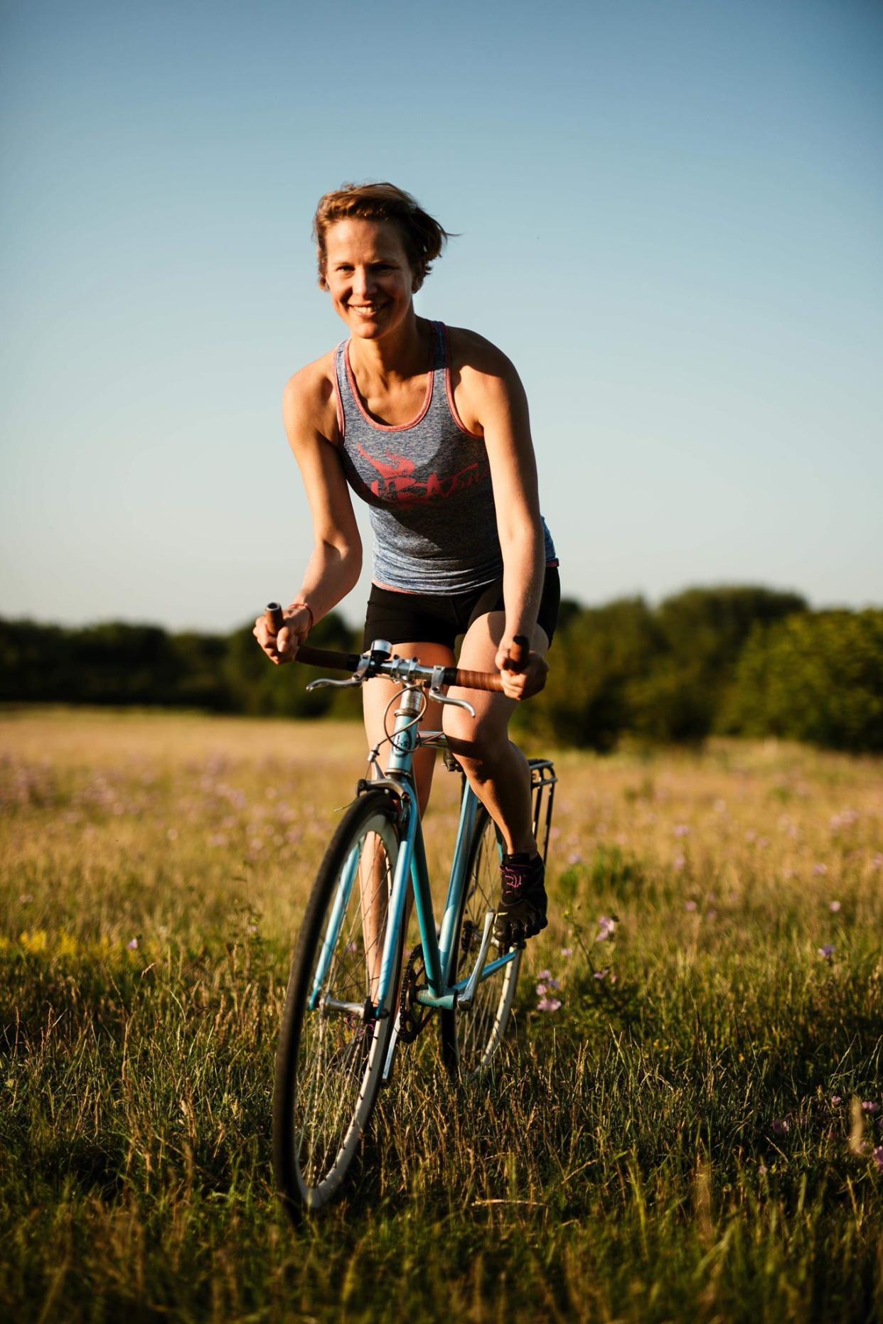 Kate Strong cycling through a field 