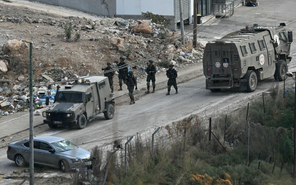 Israeli soldiers walk down a street during a raid in the Al-Far'a camp for Palestinian refugees near Tubas city in the West Bank