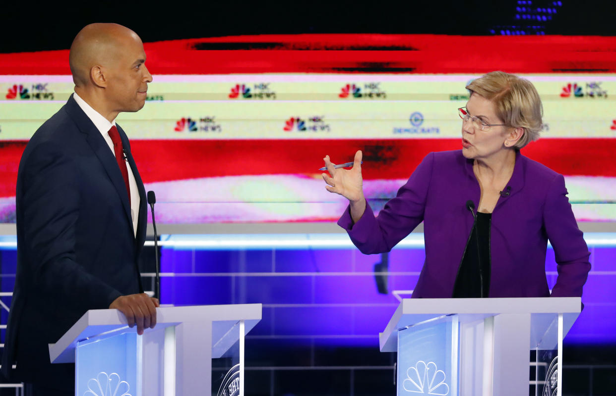 Sen. Elizabeth Warren (D-Mass.) talks with Sen. Cory Booker (D-N.J.) during the first Democratic primary debate. The 2020 presidential candidates largely stuck to their progressive stances. (Photo: Wilfredo Lee/ASSOCIATED PRESS)