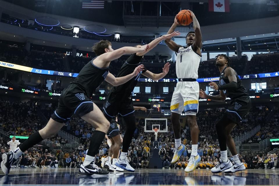 Marquette's Kam Jones shoots past Villanova's Brendan Hausen, Hakim Hart and Lance Ware during the first half of an NCAA college basketball game Monday, Jan. 15, 2024, in Milwaukee. (AP Photo/Morry Gash)