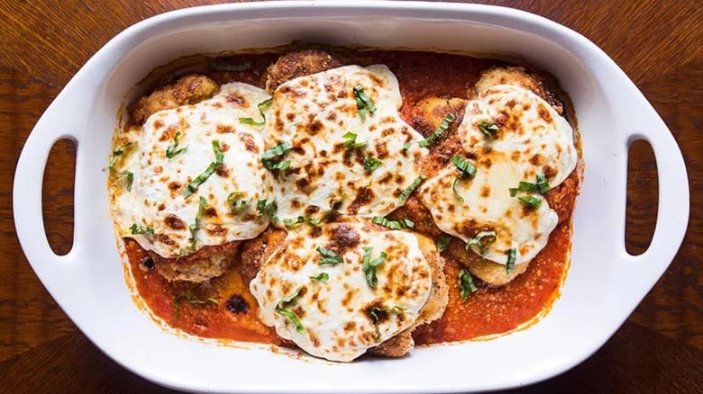 Top-down view of chicken Parmesan in an oven pan 