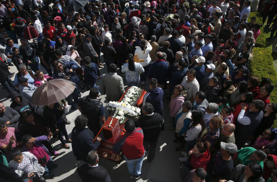 People hold a funeral for a person who died when a gas pipeline exploded in the village of Tlahuelilpan, Mexico, Sunday Jan. 20, 2019. A massive fireball that engulfed locals scooping up fuel spilling from a pipeline ruptured by thieves in central Mexico killed dozens of people and badly burned dozens more on Jan. 18. (AP Photo/Claudio Cruz)