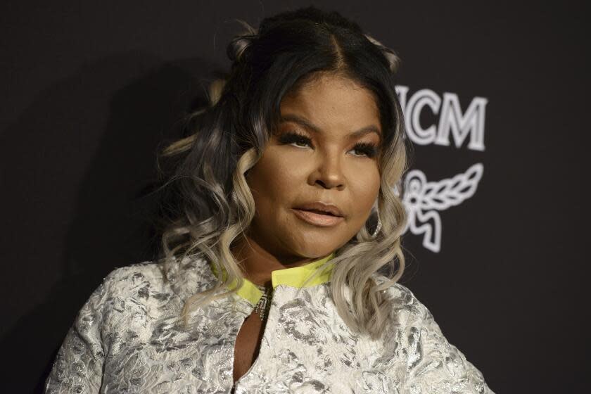 Misa Hylton Brim poses at an event against a black backdrop