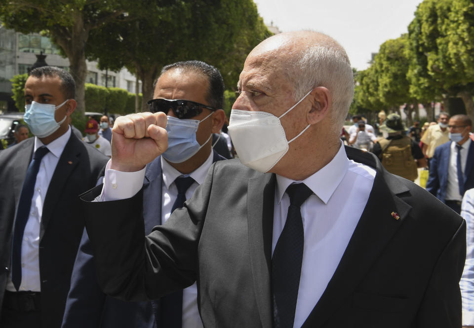 Tunisian President Kais Saied raises his fist to bystanders as he stroll along the avenue Bourguiba in Tunis, Tunisia, Sunday, Aug. 1, 2021. President Kais Saied claimed on Sunday that some desperate youth are being paid to try to leave Tunisia illegally for Europe, saying the goal is to damage the country from within. (Slim Abid/Tunisian Presidency via AP)