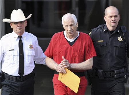 Jerry Sandusky (C) leaves the Centre County Courthouse after his sentencing in his child sex abuse case in Bellefonte, Pennsylvania in this October 9, 2012, file photo. REUTERS/Pat Little/Files