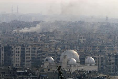 Smoke rises near damaged buildings after strikes on Aleppo, Syria December 5, 2016. REUTERS/Omar Sanadiki