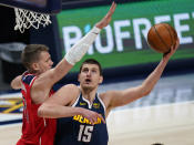 Denver Nuggets center Nikola Jokic (15) shoots as Washington Wizards center Moritz Wagner (21) defends during the first quarter of an NBA basketball game Thursday, Feb. 25, 2021, in Denver. (AP Photo/Jack Dempsey)