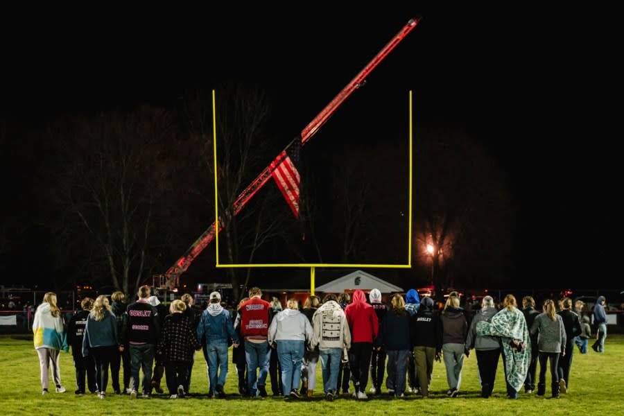 Students walk on the football field during a community prayer vigil, Tuesday, Nov. 14, 2023, at the Tuscarawas Valley Schools football stadium in Zoarville, Ohio. A charter bus filled with high school students was rear-ended by a semitruck on an Ohio highway earlier in the day, leaving several people dead and multiple others injured. (Andrew Dolph/Times Reporter via AP)