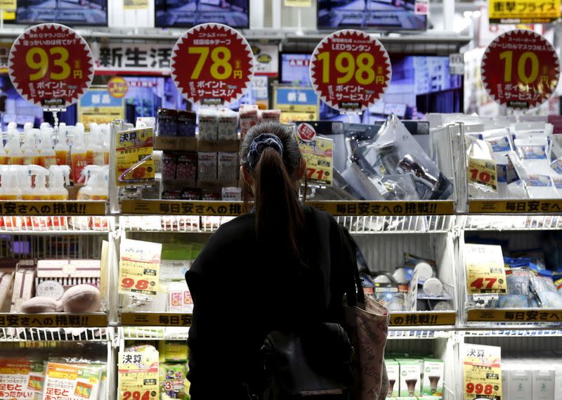 FILE PHOTO: A woman looks at items outside an outlet store at a shopping district in Tokyo