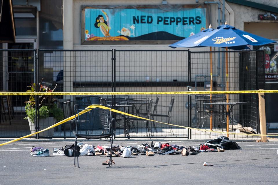 Pairs of shoes are piled behind the Ned Peppers bar belonging to victims of a shooting that took place in Dayton, Ohio, on Aug. 04, 2019.