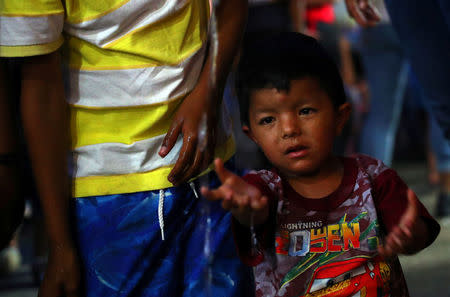 A migrant boy, part of a caravan of thousands traveling from Central America en route to the United States, washes his hands in a makeshift camp in Santiago Niltepec, Mexico, October 29, 2018. REUTERS/Hannah McKay