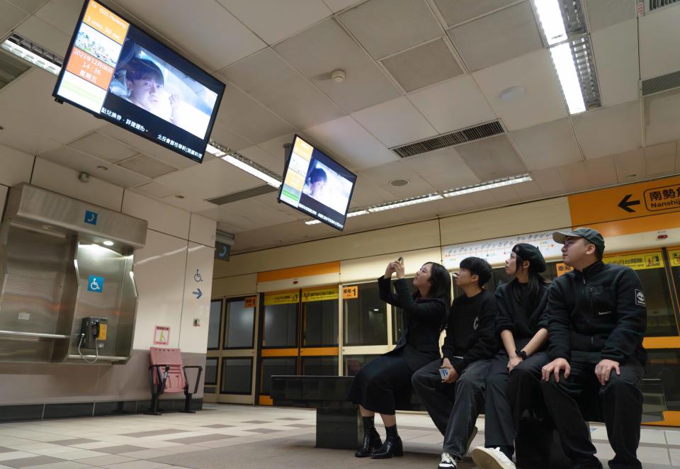 同學在捷運月台等候電視觀看自己的作品播出