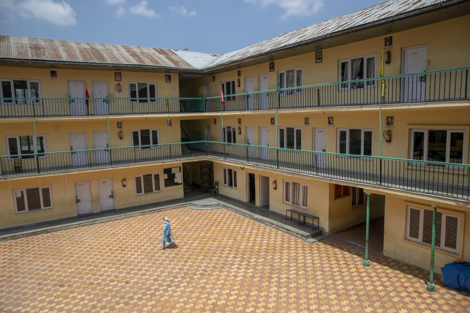 A woman walks inside an empty school that has remained closed for the past four months because of the coronavirus pandemic in Srinagar, Indian controlled Kashmir, Wednesday, July 22, 2020. Schools in the disputed region reopened after six months in late February, after a strict lockdown that began in August 2019, when India scrapped the region’s semi-autonomous status. In March schools were shut again because of the coronavirus pandemic. (AP Photo/ Dar Yasin)