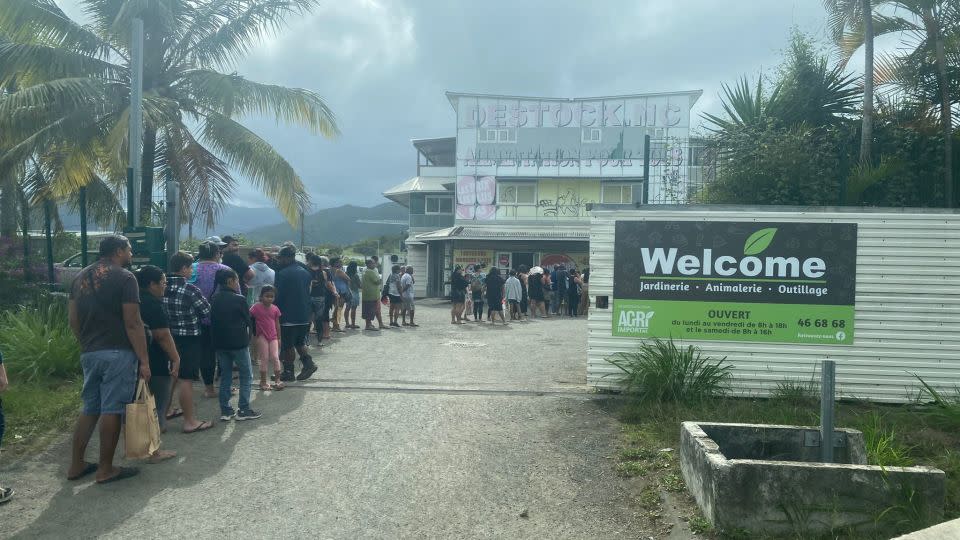 People line up at a store for supplies in New Caledonia, with larger supermarkets nearby burned and looted during the riots on the French territory. - Obtained by CNN