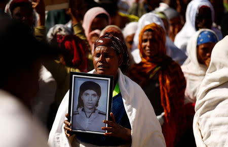 A woman carries a photograph as she mourns her family member suspected to be missing following a landslide when a mound of trash collapsed on an informal settlement at the Koshe garbage dump in Ethiopia's capital Addis Ababa, March 14, 2017. REUTERS/Tiksa Negeri