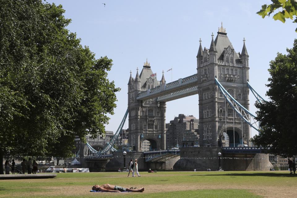 Man sunbathing by London's Tower Bridge