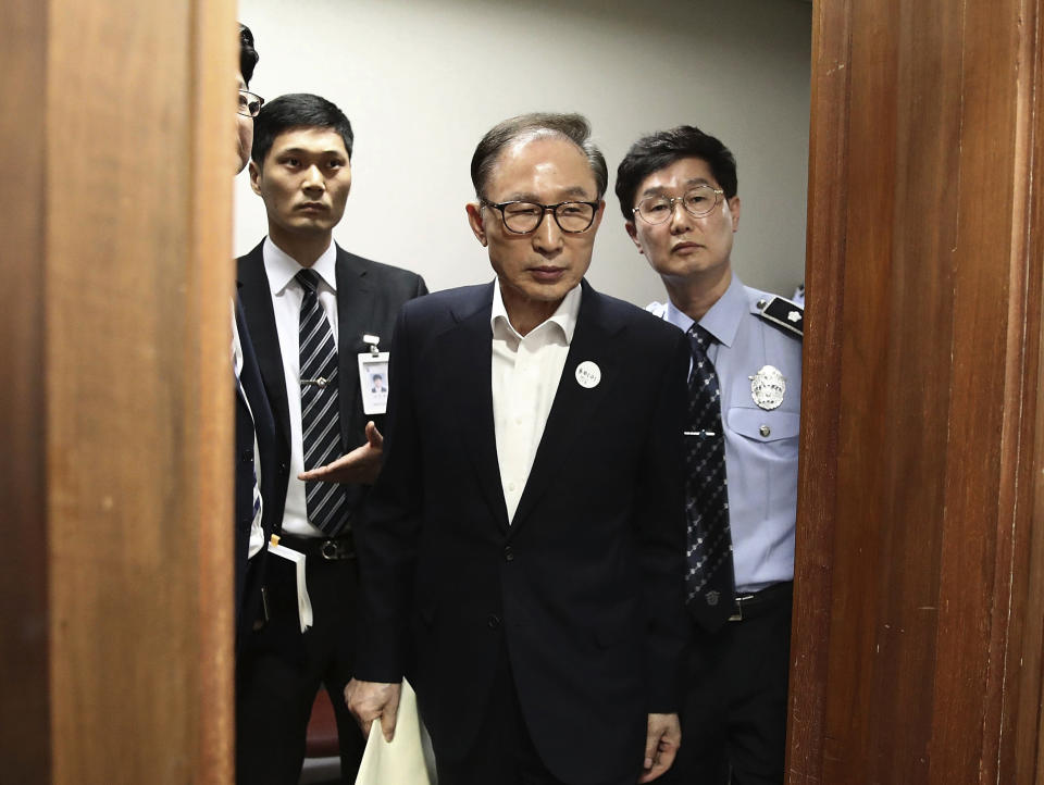 FILE - In this May 23, 2018, file photo, former South Korean President Lee Myung-bak, center, appears for his first trial at the Seoul Central District Court in Seoul, South Korea. The South Korean government of President Yoon Suk Yeol said Tuesday, Dec. 27, 2022, it will grant a special pardon to Lee, who was sentenced to a 17-year prison term for a range of corruption crimes. (Chung Sung-Jun/Pool Photo via AP, File)
