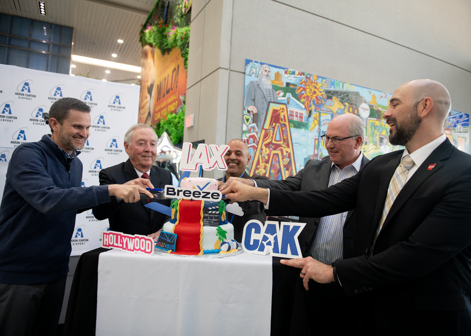 From left, Breeze Airways President Tom Doxey, Akron-Canton Airport Board Chairman John Wirtz; CAK President Ren Camacho, Team NEO CEO Bill Koehler and JobsOhio Senior Director Stuart Moynihan cut the cake at the celebration of Breeze Airways' direct flight to Los Angeles from the Akron-Canton Airport in Green.