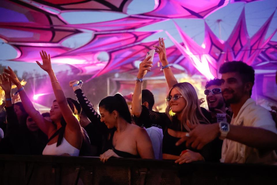 image of young people dancing under neon lights at festival