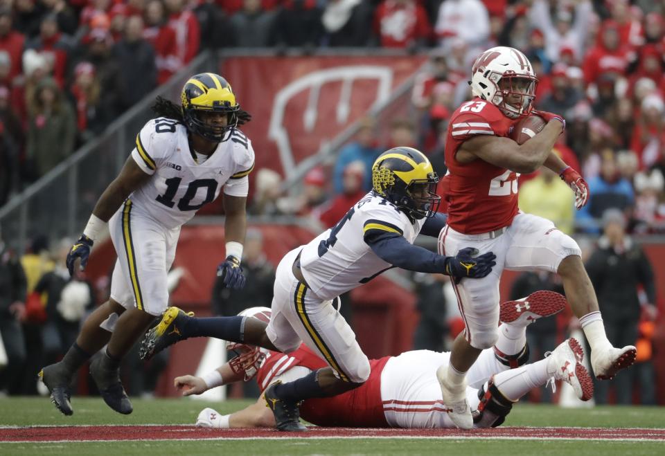 Wisconsin’s Jonathan Taylor runs past Michigan’s Josh Metellus during the second half of an NCAA college football game Saturday, Nov. 18, 2017, in Madison, Wis. (AP Photo/Morry Gash)