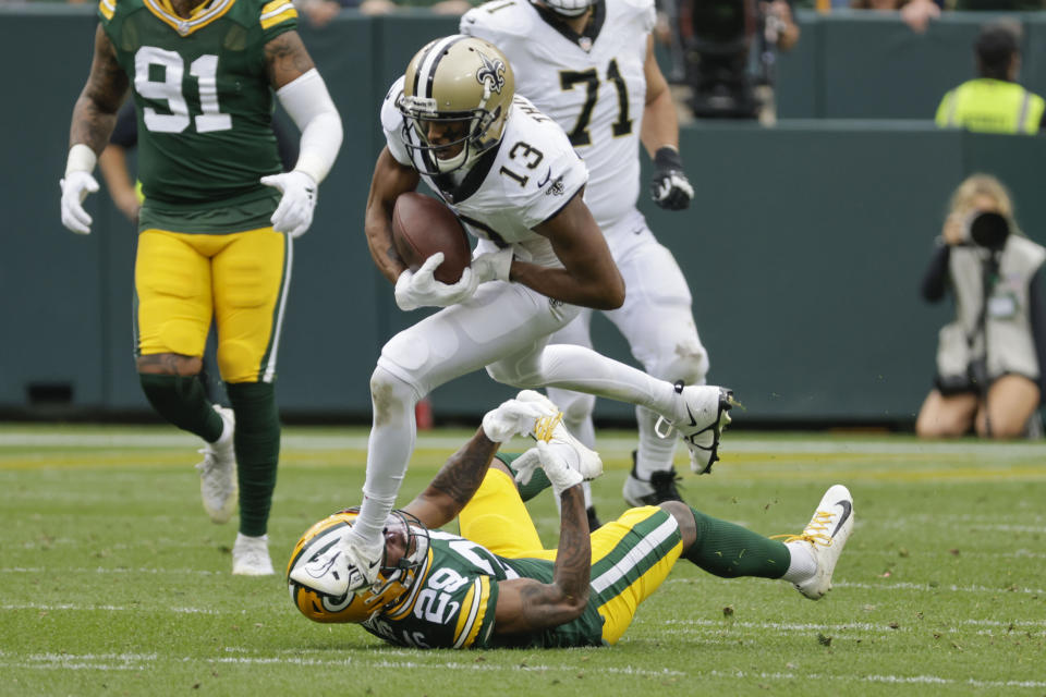 New Orleans Saints wide receiver Michael Thomas (13) carries over Green Bay Packers cornerback Rasul Douglas (29) on a pass reception during the second half of an NFL football game Sunday, Sept. 24, 2023, in Green Bay, Wis. (AP Photo/Mike Roemer)