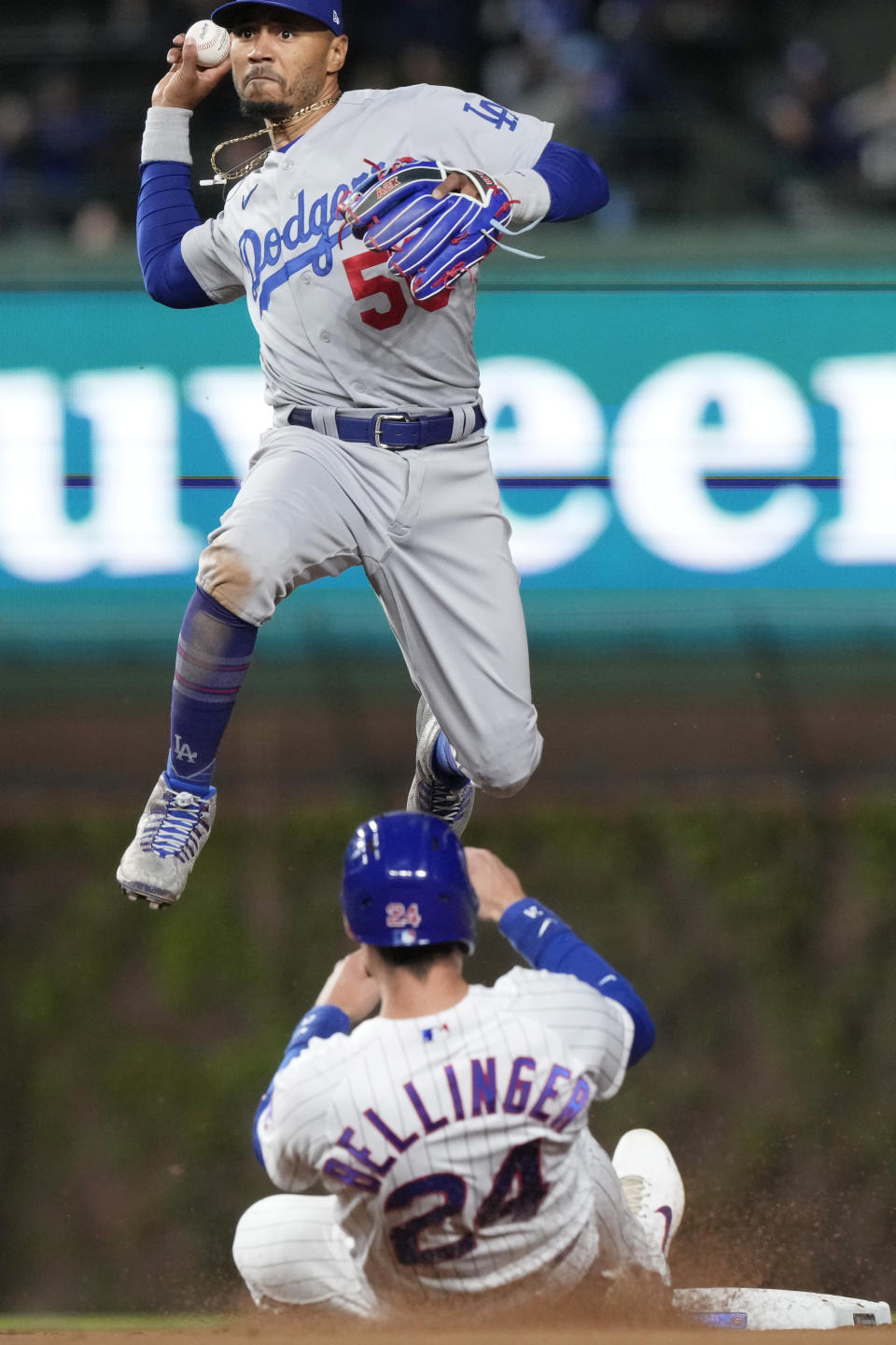 Los Angeles Dodgers shortstop Mookie Betts, top, throws out Chicago Cubs' Patrick Wisdom at first after forcing out Cody Bellinger at second during the eighth inning of a baseball game in Chicago, Thursday, April 20, 2023. The Dodgers won 6-2. (AP Photo/Nam Y. Huh)