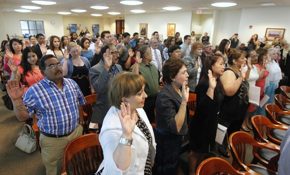 Participants take the Oath of Citizenship to become U.S. citizens in June 2014 at the United States District Court in Corpus Christi, Texas. (Rachel Denny Clow/Corpus Christi Caller-Times/AP)