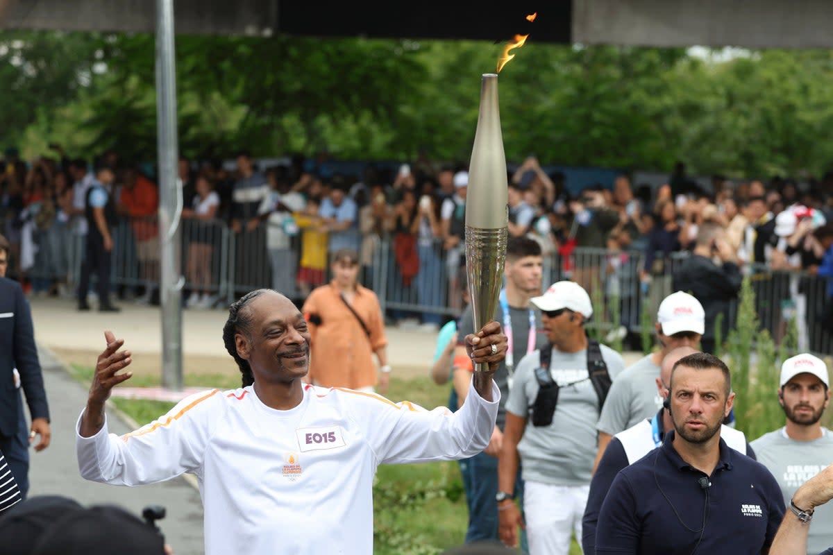 Snoop Dogg carried the Olympic flame around Saint-Denis (AP)