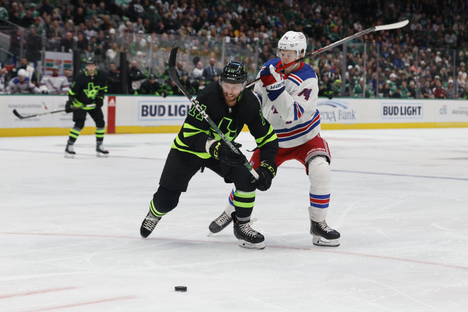 Dallas Stars center Luke Glendening (11) and New York Rangers right wing Vitali Kravtsov (74) battle for the puck during the first period of an NHL hockey game in Dallas, Saturday, Oct. 29, 2022. (AP Photo/Michael Ainsworth)
