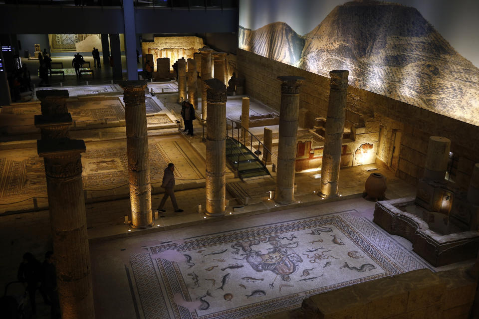People visit the main exhibition hall of Zeugma Mosaic Museum, in Gaziantep, Turkey, Saturday, Dec. 8, 2018. A display of Roman-era mosaics that were part of a U.S. university's art collection and were returned to Turkey, more than half a century after looters smuggled them out, opened at the museum. Ohio's Bowling Green State University bought the 12 mosaics from a New York gallery in 1965. Turkish and Bowling Green officials agreed to their return in May 2018. (AP Photo/Emrah Gurel)