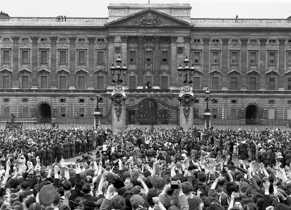 FILE - In this May 8, 1945 file photo a vast crowd assembles in front of Buckingham Palace, London to cheer Britain's Royal family as they come out on the balcony, centre, minutes after the official announcement of Germany's unconditional surrender in World War II. They are from left: Princess Elizabeth; Queen Elizabeth; King George VI; and Princess Margaret. Nazi commanders signed their surrender to Allied forces in a French schoolhouse 75 years ago this week, ending World War II in Europe and the Holocaust. Unlike the mass street celebrations that greeted this momentous news in 1945, surviving veterans are marking V-E Day this year in virus confinement, sharing memories with loved ones, instead of in the company of comrades on public parade. (AP Photo/Leslie Priest, File)