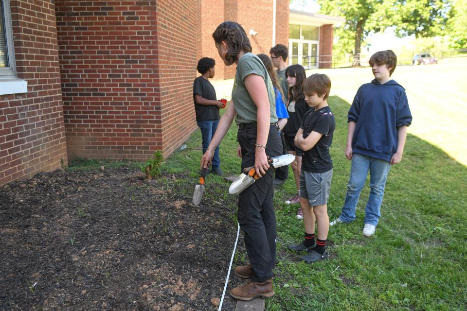 Erica Lisowe from Knox Garden Alliance shows Vine Middle School students where to plant seedlings during the after-school garden club meeting.