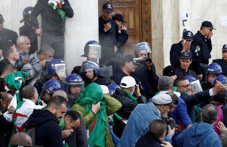 People react to tear gas sprayed by police officers during a protest against the appointment of interim president Abdelkader Bensalah demanding radical changes to the political system, in Algiers, Algeria April 10, 2019. REUTERS/Ramzi Boudina