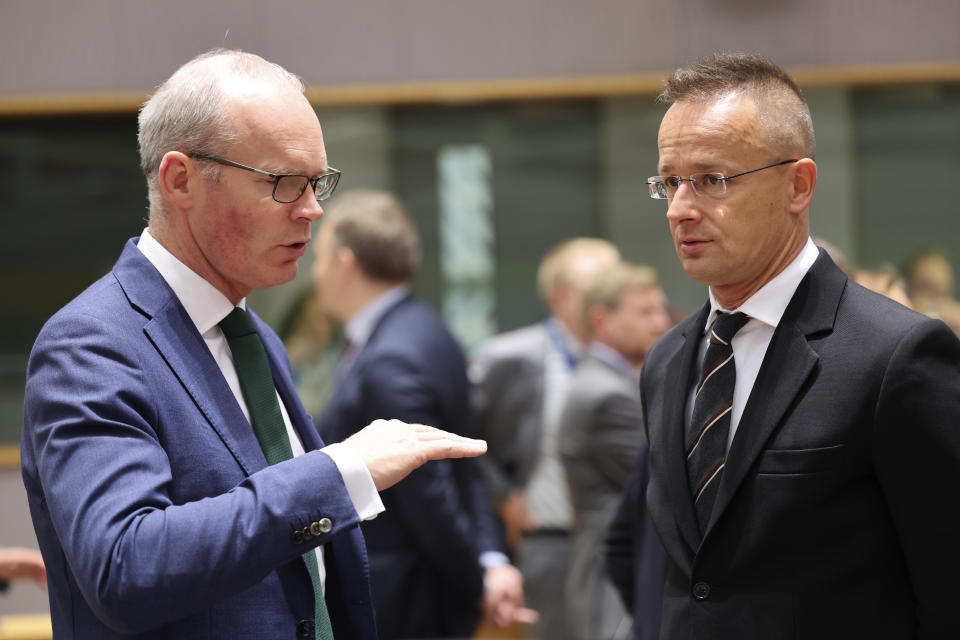 Ireland's Minister for Trade Simon Coveney, left, speaks with Hungary's Foreign Minister Peter Szijjarto during a meeting of EU trade ministers at the European Council building in Brussels, Thursday, May 25, 2023. European Union Trade Ministers meet in Brussels Thursday to discuss, among other issues, the state of play of the trade relations with the United States and recent developments in EU-China trade relations. (AP Photo/Geert Vanden Wijngaert)