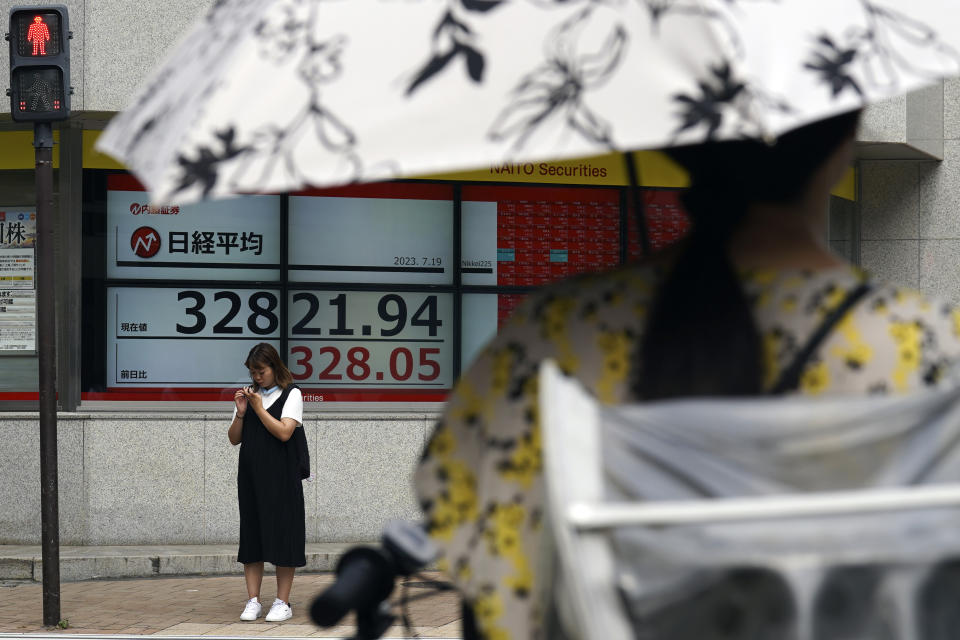 A person stands in front of an electronic stock board showing Japan's Nikkei 225 index at a securities firm Wednesday, July 19, 2023, in Tokyo. Asian shares are mixed after Wall Street’s frenzy around artificial intelligence helped pushed U.S. stocks to their best level in more than 15 months. (AP Photo/Eugene Hoshiko)