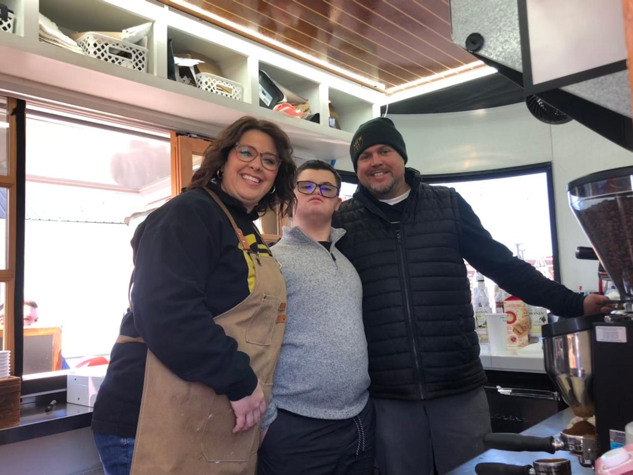 Whitney, Wyatt and Chris Justis pose in the Brew 21 Extra Chromosome Coffee Company trailer at the 417 Tattoo Collaborative Flash Bash in Fair Grove on Jan. 20, 2023. The Justises started the coffee trailer as a way for their son Wyatt, who has Down syndrome, to work with them.