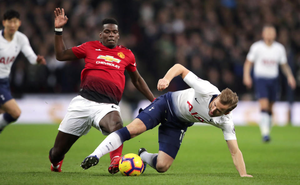 Tottenham’s Harry Kane attempts to fend off attention from Paul Pogba