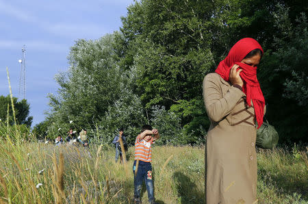 Migrants from Afghanistan walk after they crossed the border from Serbia to Hungary, near the village of Asotthalom, Hungary, on June 29, 2015. REUTERS/Laszlo Balogh