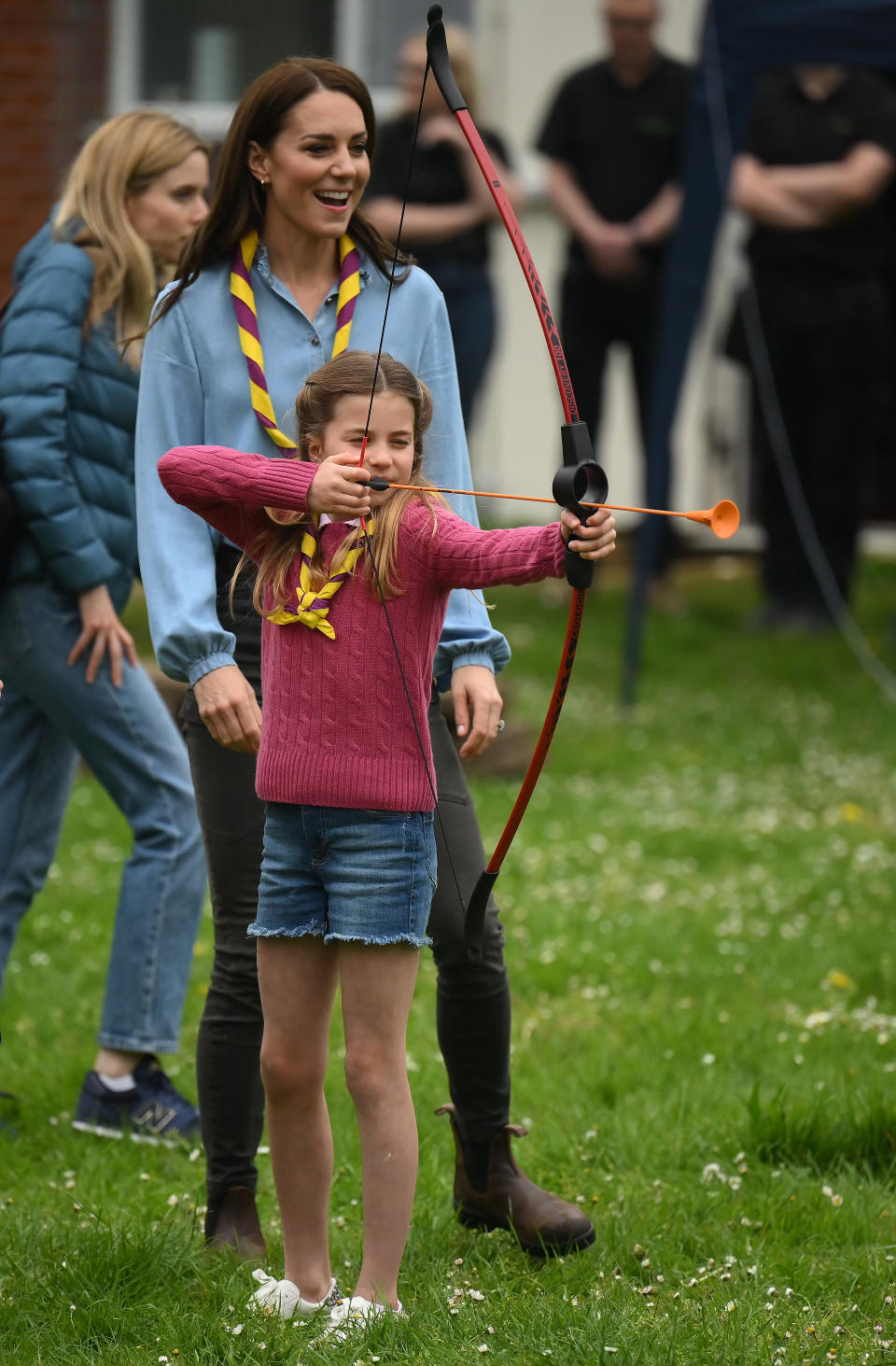 LONDON, ENGLAND - MAY 08: Watched by her mother Catherine, Princess of Wales, Princess Charlotte of Wales tries her hand at archery while taking part in the Big Help Out, during a visit to the 3rd Upton Scouts Hut in Slough on May 8, 2023 in London, England. The Big Help Out is a day when people are encouraged to volunteer in their communities. It is part of the celebrations of the Coronation of Charles III and his wife, Camilla, as King and Queen of the United Kingdom of Great Britain and Northern Ireland, and the other Commonwealth realms that took place at Westminster Abbey on Saturday, May 6, 2023. (Photo by Daniel Leal - WPA Pool/Getty Images)