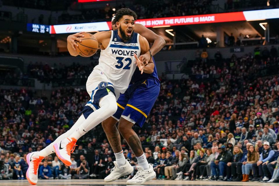 Minnesota Timberwolves center Karl-Anthony Towns (32) drives to the basket as Golden State Warriors center Kevon Looney (5) defends during a Nov. 27 game.