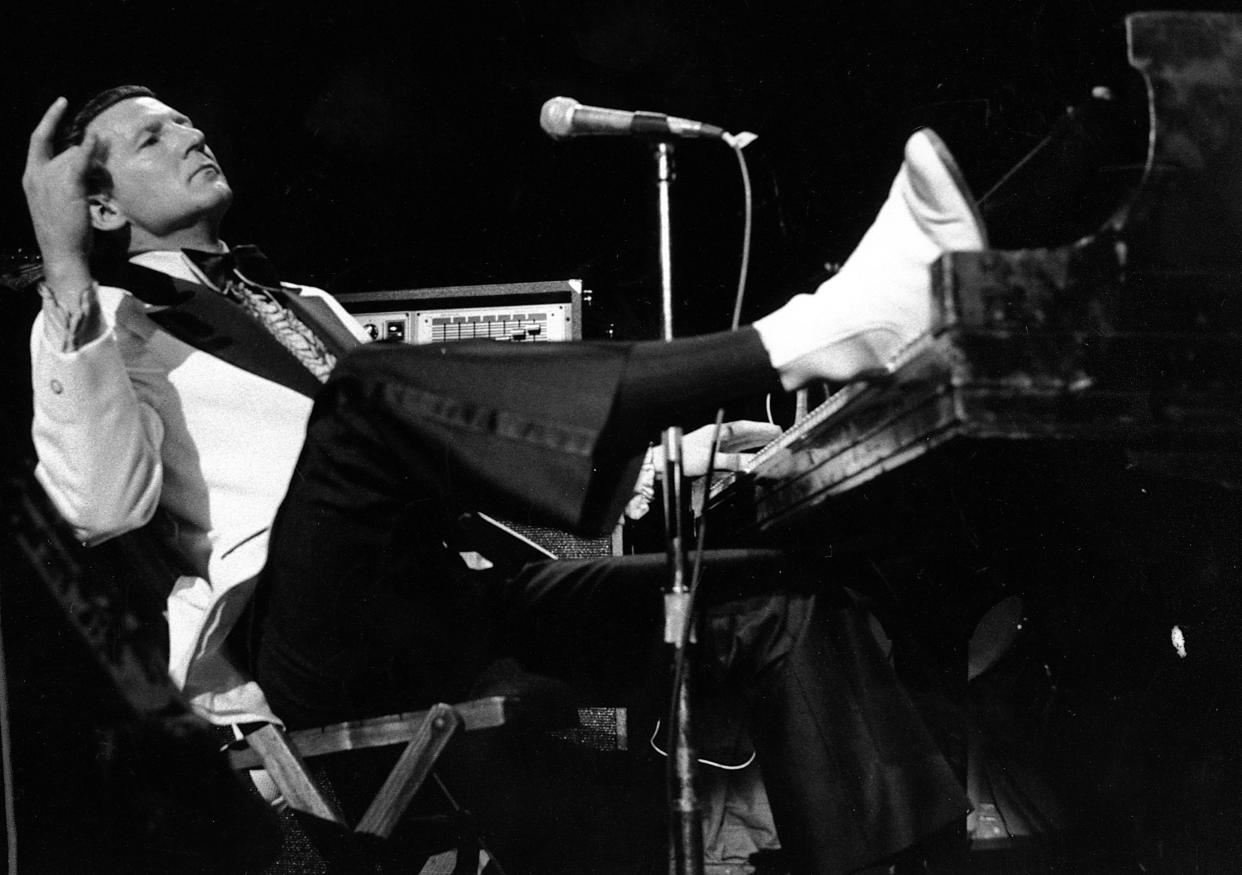 Jerry Lee Lewis props his foot on the piano as he lays back and acknowledges he applause of fans during the fifth annual Rock 'n' Roll Revival at New York's Madison Square Garden on March 14, 1975.