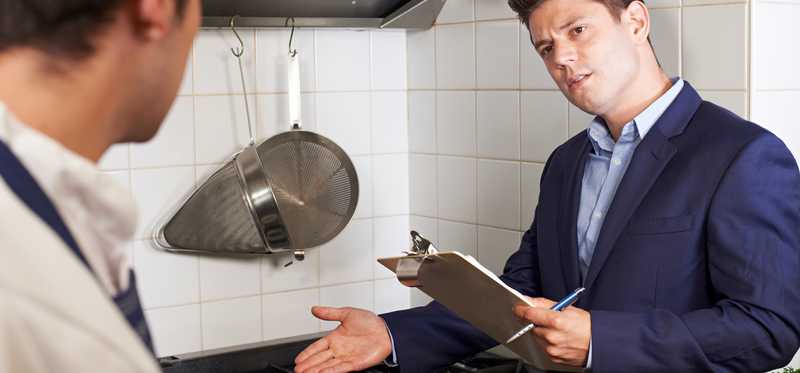 A health inspector checks a kitchen.